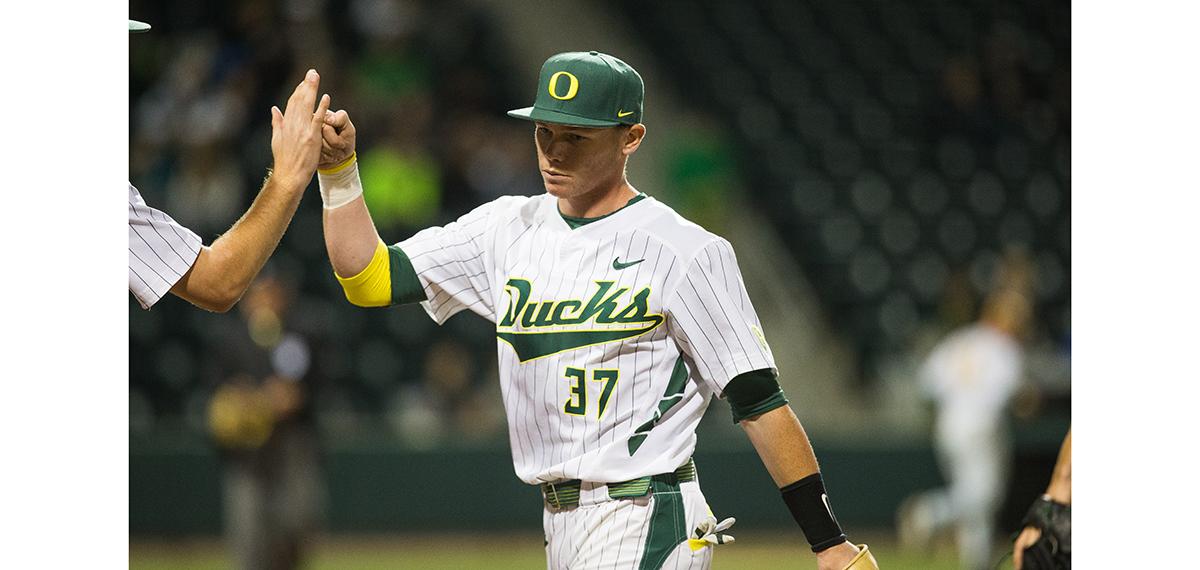 Oregon infielder Mitchell Tolman (37) fist bumps a player between innings. The Oregon Ducks played the San Francisco Dons at PK Park in Eugene, Oregon on Tuesday, March 10. (Taylor Wilder/Emerald)