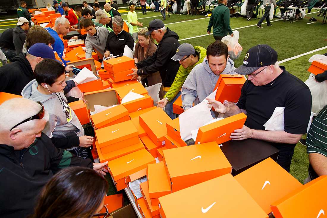 A crowd of people look through endless orange boxes to find shoes. The Oregon Athletic Department hosts their annual Equipment Surplus Sale at the Moshofsky Center in Eugene, Ore. on Sunday, April 19, 2015. (Ryan Kang/Emerald)