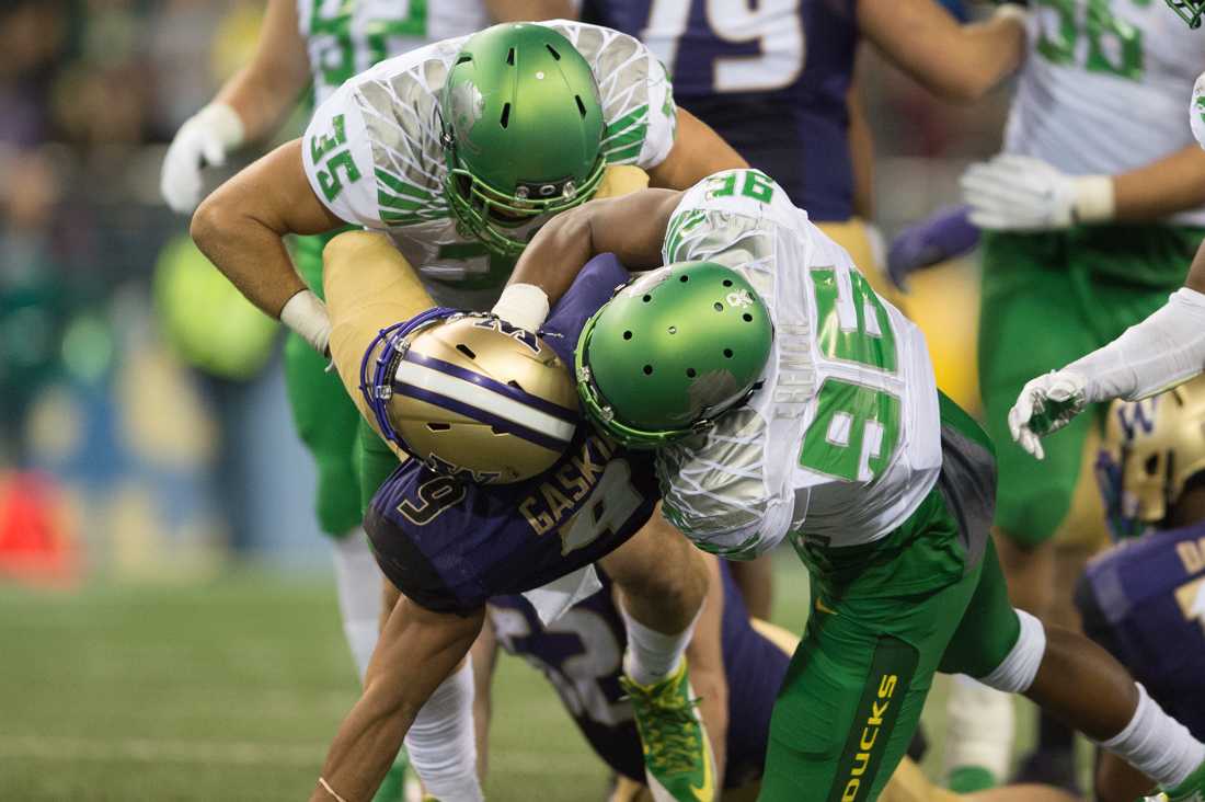 Oregon Ducks linebacker Joe Walker (35) and Oregon Ducks linebacker Christian French (96) work together to bring down Washington Huskies fullback Myles Gaskin (9). The unranked Oregon Ducks travel north in hopes of extending their 11 game win streak against the Washington Huskies at Husky Stadium in Seattle, Wash. on Oct. 17, 2015. (Adam Eberhardt/Emerald)