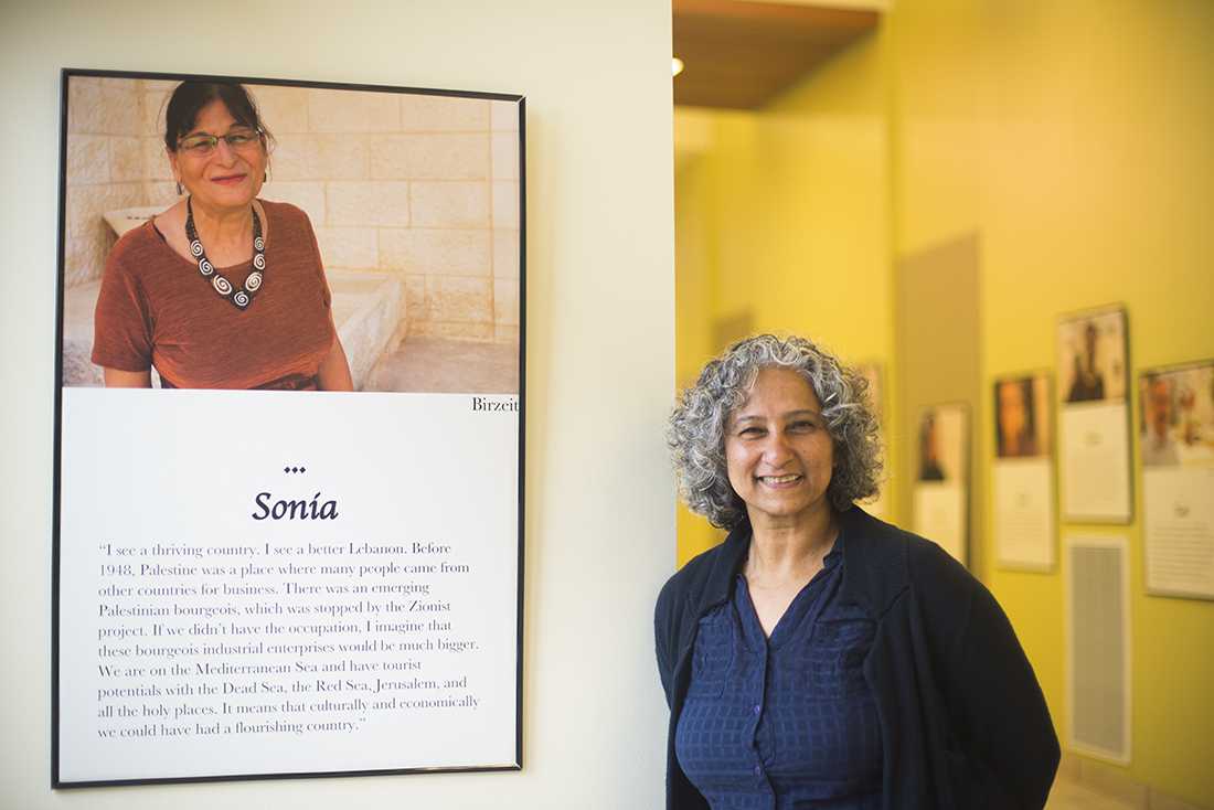 Dr. Irum Shiekh poses in front of her photos that she collected while she was living in Jerusalem, Ramallah, Bethlehem, and Birzei.