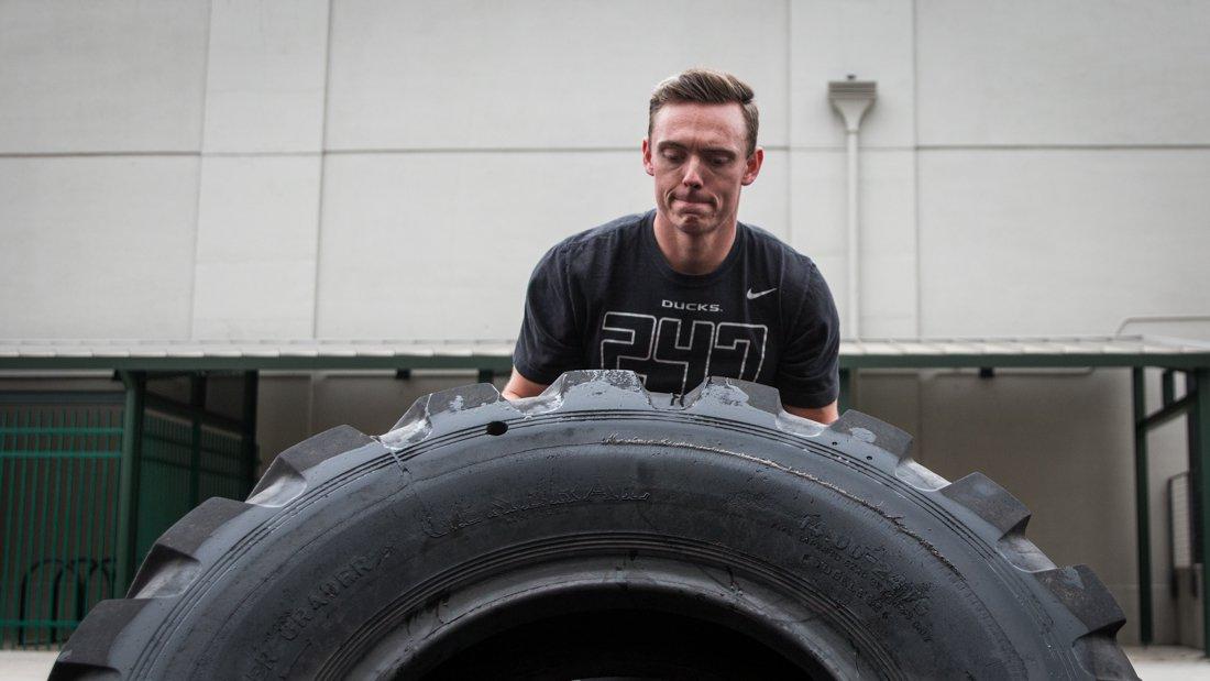 <p>Chase Clemens, a senior advertisement major at the University of Oregon performs a tire flip. (Samuel Marshall/Emerald)</p>