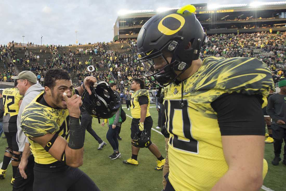 Oregon Ducks linebacker Troy Dye (35) pretends to take photos of Oregon Ducks quarterback Justin Herbert (10) as he walks off the field after the game. The Oregon Ducks host the Arizona State Sun Devils at Autzen Stadium in Eugene, Ore. on Oct. 29, 2016. (Adam Eberhardt/Emerald)