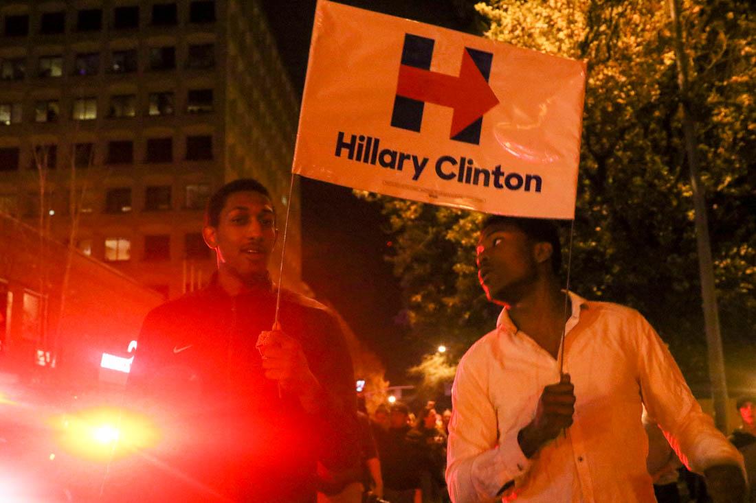 Protestors hold a Hillary Clinton campaign sign as they walk to the city hall in Eugene, Ore. on Nov. 8, 2016. (Kaylee Domzalski/Emerald)