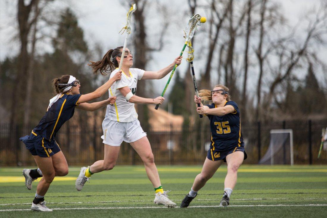 <p>Oregon Ducks midfielder Bella Pyne (14) attempts a shot as California Golden Bears Elizabeth Koehler (35) and Charlotte Biffar (1) defend. The University of Oregon Women’s Lacrosse team host the California Golden Bears at Papé Field on Feb. 19, 2015. (Aaron Nelson/Emerald)</p>