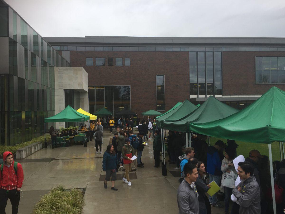 <p>Various campus groups set up in the rain to welcome prospective students during Duck Days. (Max Thornberry/Emerald)</p>