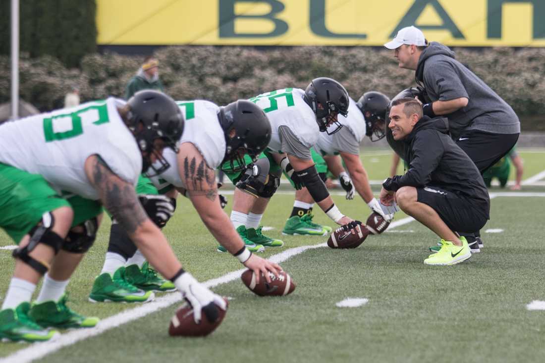 Oregon Ducks co-offensive coordinator Marcus Arroyo smiles as the centers prepare to snap footballs to their quarterbacks. The Oregon Ducks hold practice during their spring season at the Hatfield-Dowlin Complex practice fields in Eugene, Ore. on Friday April 21, 2017. (Aaron Nelson/Emerald)