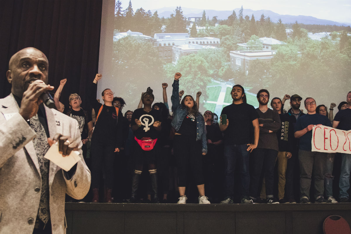 Members of the UO Student Collective flood the stage in protest. (Sarah Northrop/Emerald)