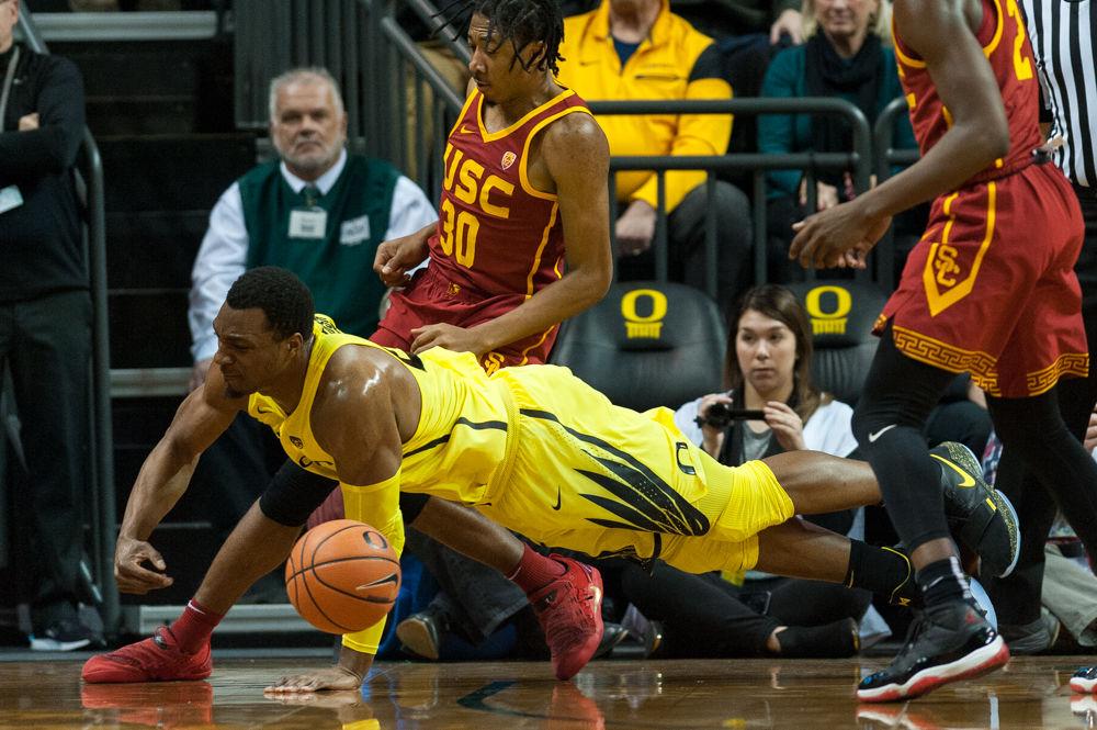 Oregon forward Mikyle McIntosh (22) dives to keep the ball from going out of bounds. Oregon basketball take on the University of Southern California at Matthew Knight Arena in Eugene, Ore. on Jan. 18th, 2018. (Ben Green/Emerald)