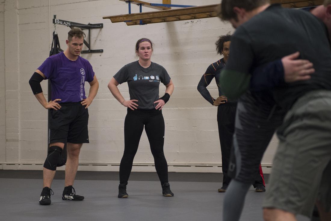 The mat room, hidden in the back hallways of the University of Oregon Student Recreation Center, smells of sweat and dirty socks. It&#8217;s 6 p.m. on a Tuesday evening and Katie Kelly sits on the mat. She puts on her wrestling shoes and ties her long, wavy hair into a &#8230;