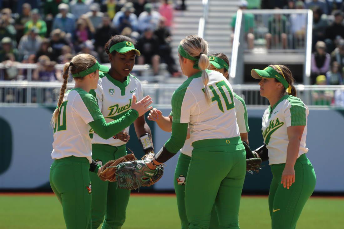 The Ducks high five at the start of an inning. The Oregon Ducks play the Stanford Cardinals at Jane Sanders Stadium in Eugene, Ore. on April 22, 2018. (Devin Roux/Emerald)