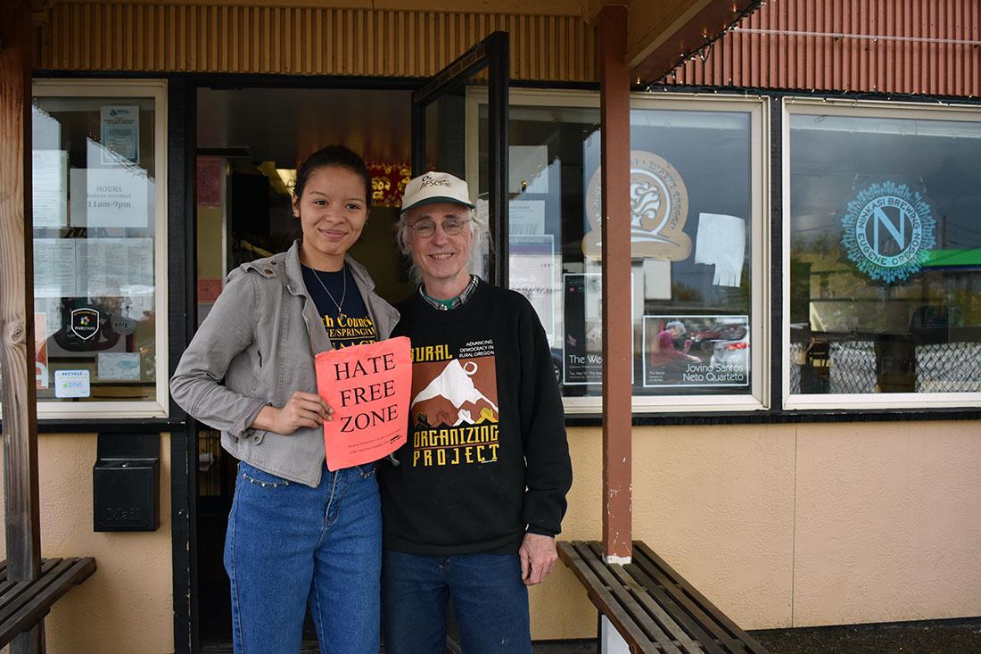 Community Alliance of Lane County coordinators Brittany Judson and Michael Carrigan stand outside Ankgor Wat, a local restaurant where volunteers gathered Saturday in a leafleting campaign response to hate vandalism in the area.