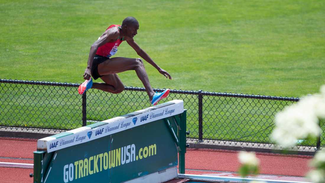 Benjamin Kigen leaps over the water hazard during the 3000 steeplechase. The 44th Prefontaine Classic is held at Hayward Field in Eugene, Ore. on Saturday, May 26, 2018. (Benjamin Green/Emerald)