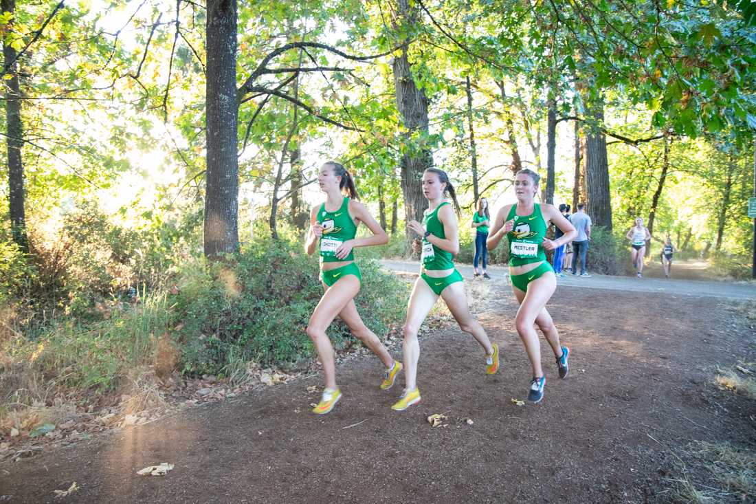 Freshman Taylor Chiotti, sophomore Rennie Kendrick, and freshman Caramia Mestler attempt to catch the pack ahead them. Oregon Ducks Cross Country started their season at Alton Baker Park on Sept. 6 2018. (Rylee Marron/Emerald)