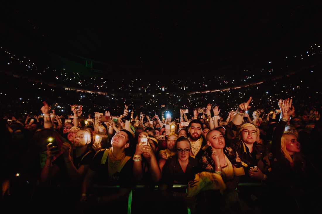 Twenty One Pilots fans wave their hands and dance. Among them is a fan named Emily, who said that she and her friends waited around the Moda Center since Monday, Nov. 12, for a spot in the front row. Twenty One Pilots brings the &#8216;Bandito&#8217; tour to the sold-out Moda Center in Portland on Nov. 15, 2018. (Sarah Northrop/Emerald)