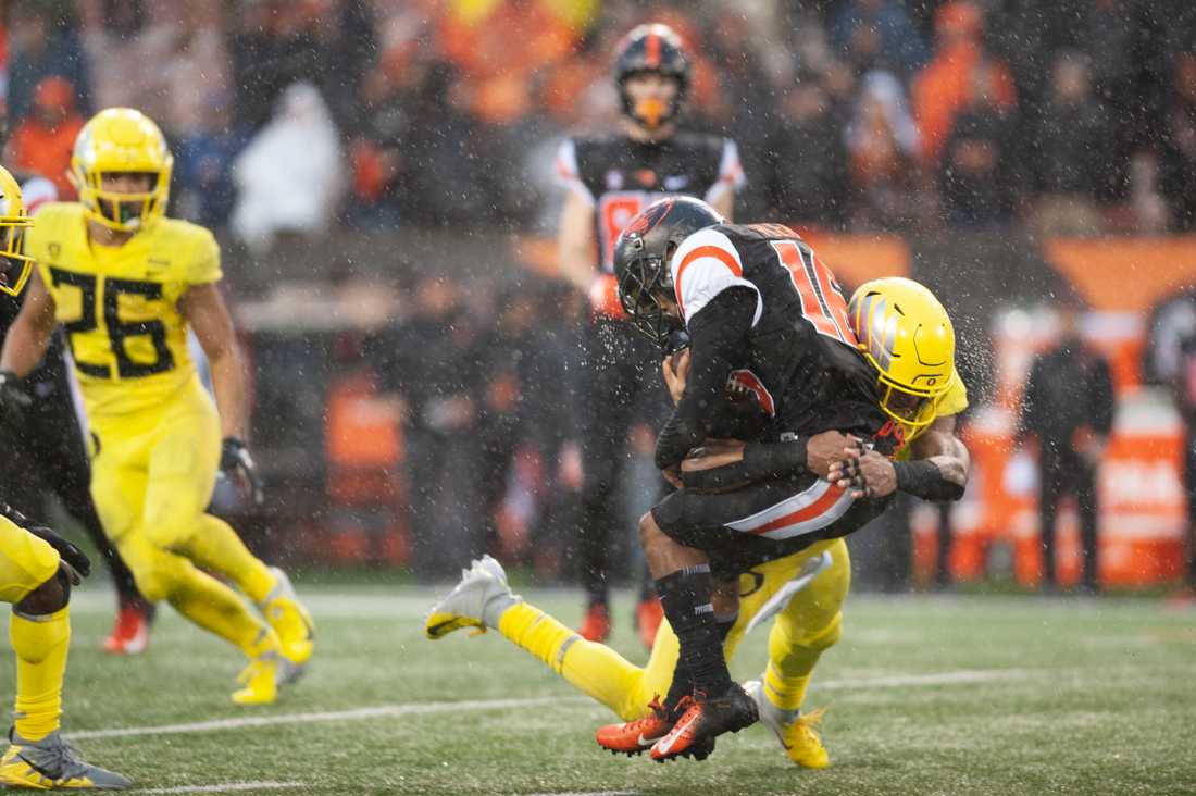 Ducks safety Jevon Holland (8) tackles Beavers wide receiver Champ Flemings (16). Oregon Ducks football takes on the Oregon State University Beavers for the Civil War at Reser Stadium in Corvallis, Ore. on Nov. 23, 2018. (Sarah Northrop/Emerald)