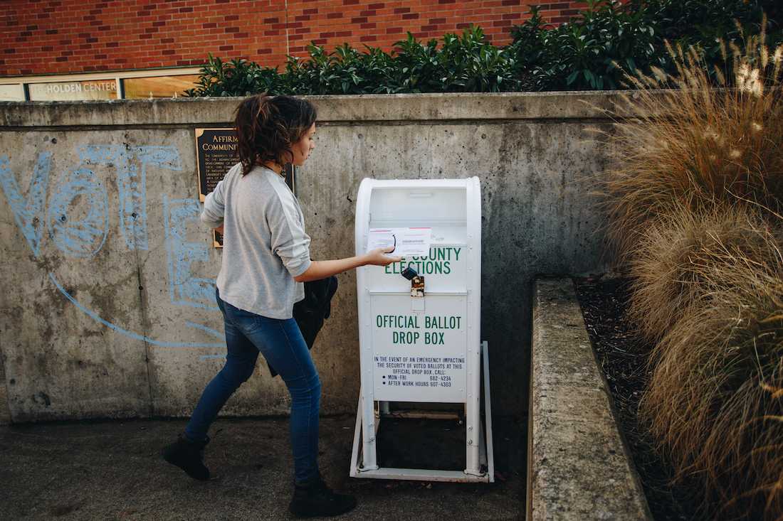 A student delivers their ballot to an official ballot drop box in front of the EMU on the University of Oregon campus on Election Day, Nov. 6, 2018. (Sarah Northrop/Emerald)