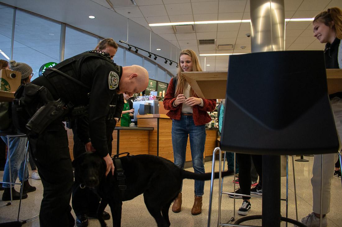 <p>Officer Phillips shows off Onyx the dog to a group of students during Coffee With a Cop. (Henry Ward/Daily Emerald)</p>