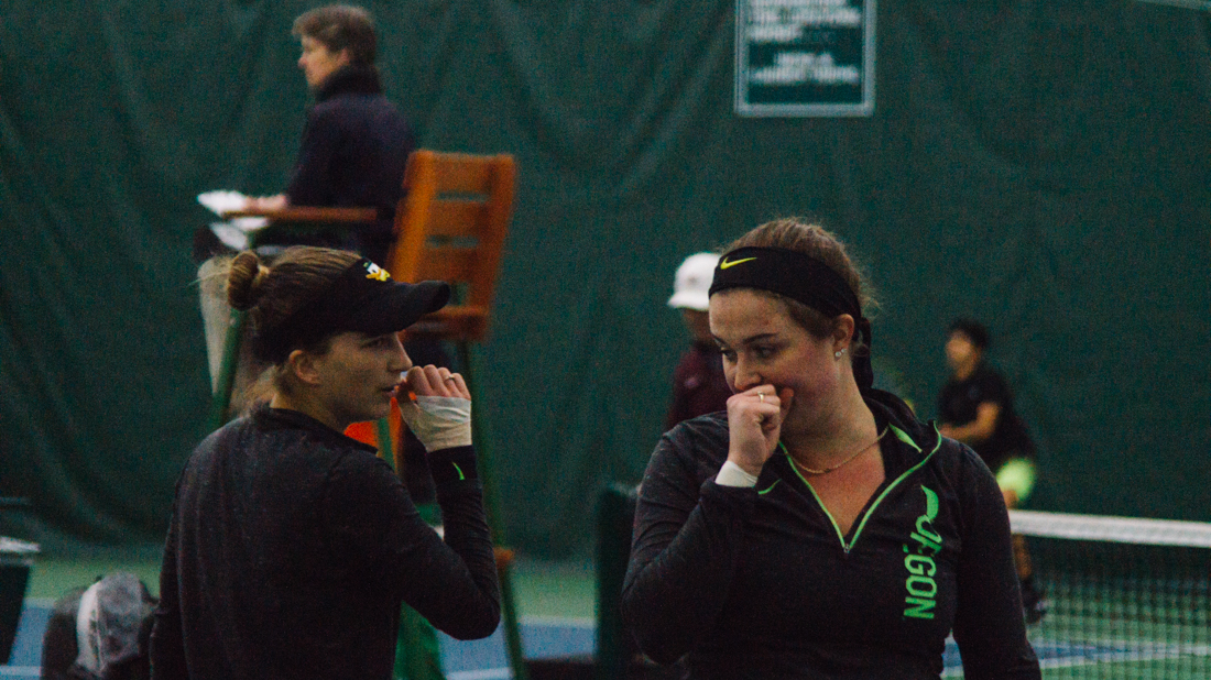 Ducks teammates talk to each other between a set. Oregon Ducks women's tennis takes on University of Montana at the Student Tennis Center in Eugene, Ore. on Feb. 15, 2019. (Connor Cox/Emerald)