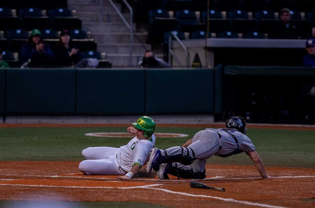 <p>Oregon Ducks first baseman Gabe Matthews slides safely into home. Oregon Ducks baseball takes on University of Washington at PK Park in Eugene, Ore. on Mar. 15, 2019. (Henry Ward/Emerald)</p>