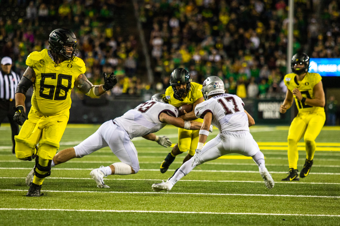 Ducks running back Travis Dye (26) engages in contact with a Grizzly. Oregon Ducks football takes on the Montana Grizzlies at Autzen Stadium in Eugene, Ore. on Sept. 14, 2019. (D L Young/Emerald)