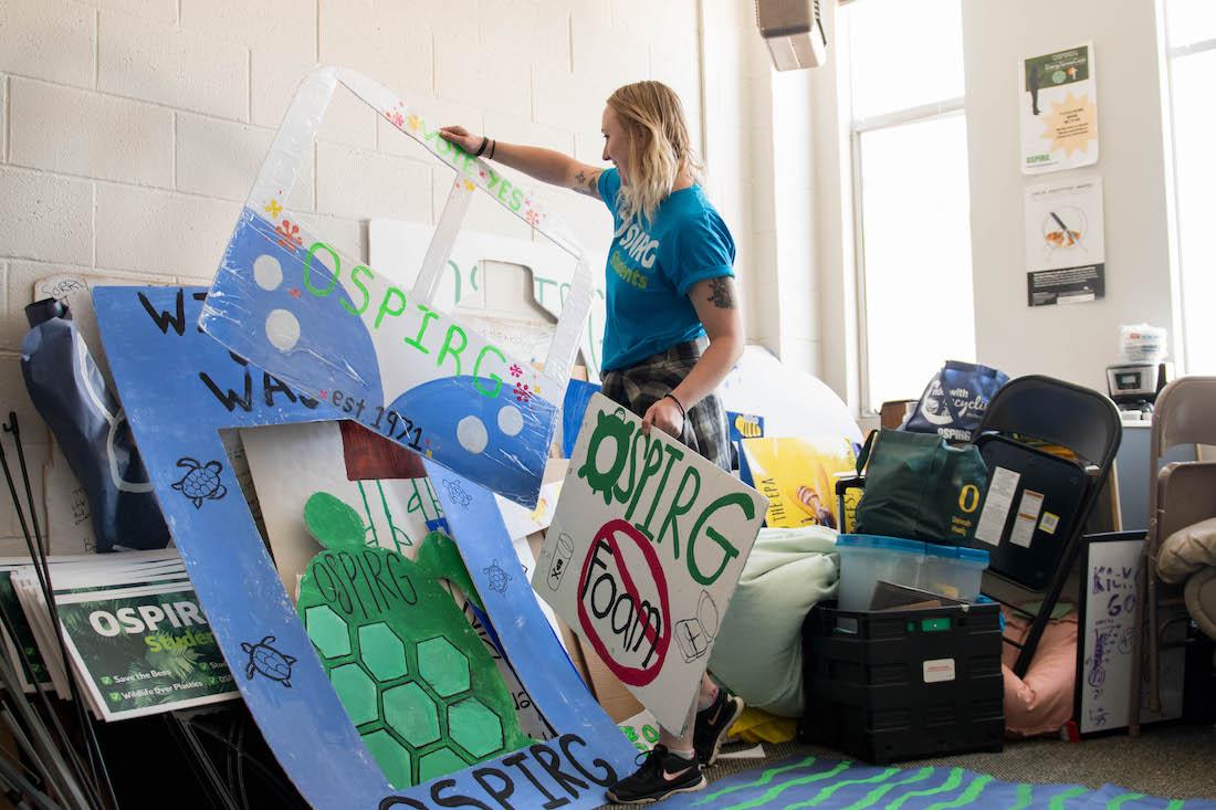 Alyssa Gilbert, the chapter chair for the University of Oregon OSPIRG chapter, looks through different posters and signs that have been created by the group. The UO OSPIRG chapter is fighting to end polystyrene food containers in the state of Oregon. The University of Oregon OSPIRG chapter is a student group on campus that focuses on informing students and works toward creating a sustainable future. Eugene, Ore. May 3, 2019. (Madi Mather/Emerald)