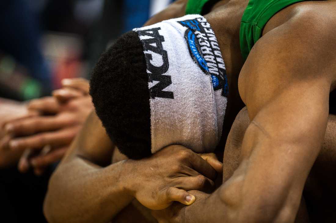 Ducks forward Francis Okoro (33) burries his head in his legs as time in the second half winds down. Oregon Ducks men's basketball takes on University of Virginia at KFC Yum! Center in Louisville, Ky. on March 28, 2019. (Ben Green/Emerald)