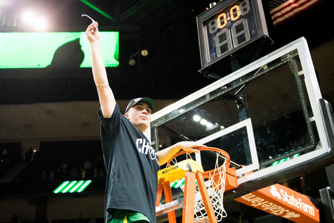 <p>Peyton Pritchard (3), guard for the Ducks, cuts a piece of net. Oregon Ducks men's basketball takes on Stanford at Matthew Knight Arena in Eugene, Ore. on Mar. 7, 2020. (Madi Mather/Emerald)</p>