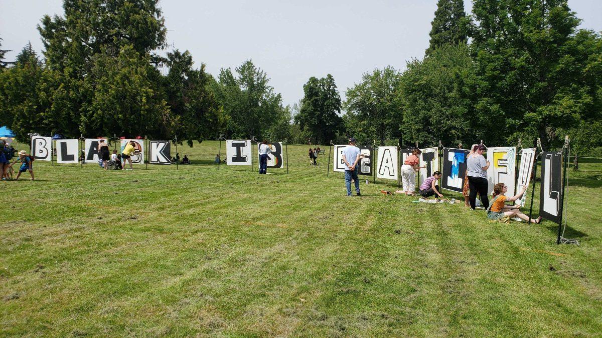 Attendees painted canvases that spelled out "black is beautiful" at the Black Unity Juneteenth celebration on June 19. (James Croxton / Daily Emerald)