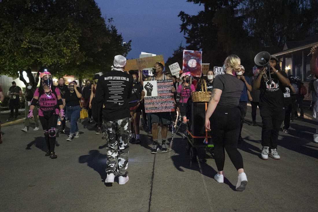 <p>Protesters march through the streets of Springfield and encourage residents to come outside to support Black Lives Matter. Black Unity held a march for the anniversary of the Elaine Massacre on Wednesday night, Sept. 30, 2020, in Springfield, Ore. Springfield Police escorted the peaceful march and separated confrontation between protesters and counter-protesters. (Kevin Wang/Daily Emerald)</p>