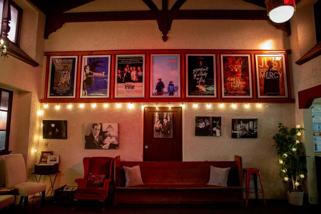 The lobby of the theater is decorated with old movie posters and antique furniture. A church pew is used as lobby seating. Bijou Art Cinemas, a former church from 1925, is now a movie theater in showing mostly indie dramas and documentaries in Eugene, Ore. on Feb. 22, 2020. (Maddie Knight/Emerald)