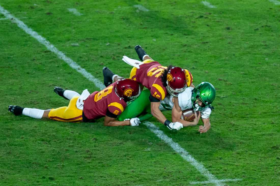 Ducks running back Travis Dye (26) gets tackled. Oregon Ducks football take on USC Trojans in the Pac-12 Championship game at Los Angeles Memorial Coliseum in Los Angeles, Calif., on Dec. 18, 2020. (Maddie Knight/Emerald)