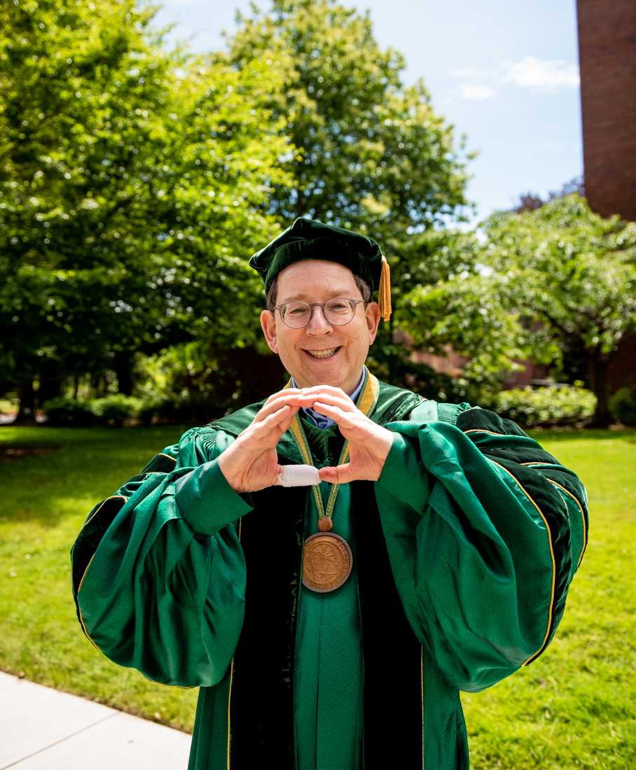 University of Oregon President Michael H. Schill throws up the Oregon &#8220;O&#8221; as he walks over to begin the Graduation Stage Procession. After a full academic year of online school, the class of 2021 participated in the University of Oregon's traditional Grad Parade on June 12, 2021. (Ian Enger/Emerald)