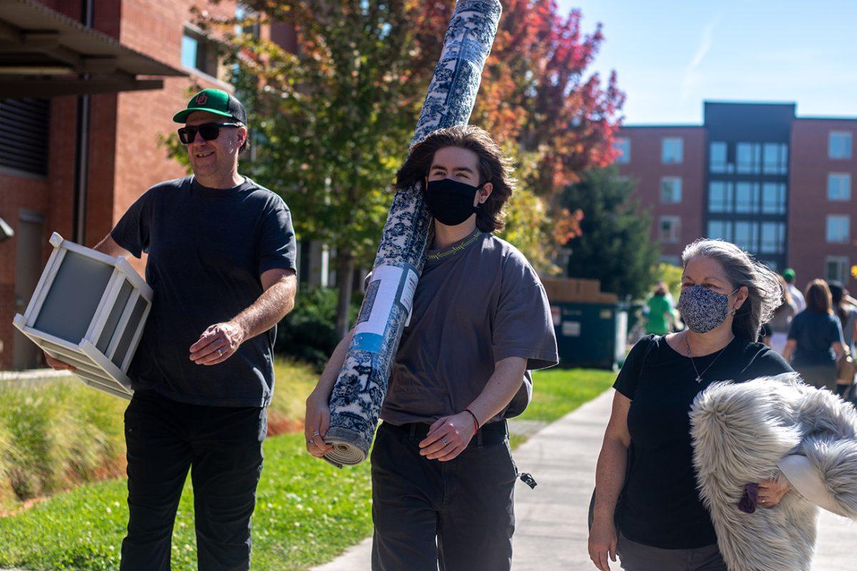 Liam Sack (center) walks with his parents while moving in on move in day, September 23, 2021. University of Oregon students are preparing to resume in person activities across campus during fall term. (Will Geschke/Emerald)