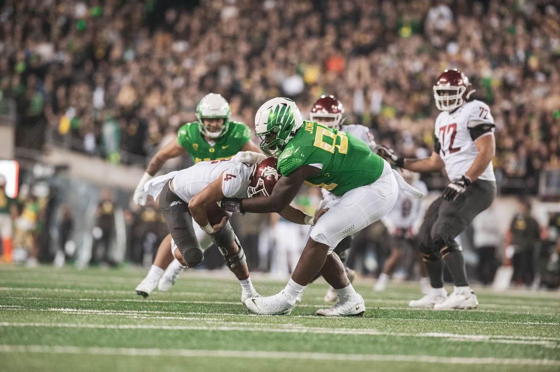 Ducks Jayson Jones (93) takes down Cougar quarterback Jayden De Laura (4). Ducks football take on the Washington State Cougars at Autzen Stadium in Eugene, Ore., on Nov. 13, 2021. (Maddie Stellingwerf)