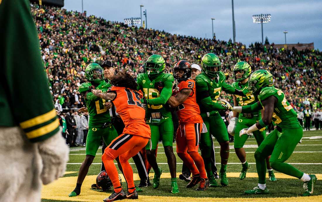 Beavers wide receiver Anthony Gould (15) loses his helmet in a scuffle while grabbing on to Ducks cornerback DJ James (0). The University of Oregon Ducks hosted and defeated the Oregon State Beavers 38-29, claiming the Pac-12 North champions title. (Emerald/ Ian Enger)