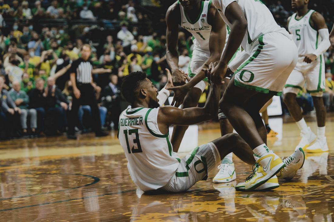 Quincy Guerrier (13), is helped up by Duck teamates after taking a charge. The Oregon Ducks Men&#8217;s Basketball team takes on the Baylor Bears, on December 18th, 2021, at Matthew Knight Arena. (Serei Hendrie/Emerald)