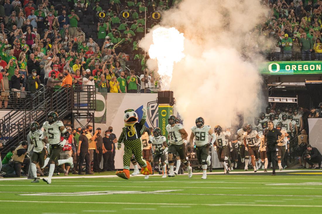 The Ducks charge out of the tunnel prior to kickoff of the Pac-12 championship game. The Oregon Ducks take on the Utah Utes at Allegiant Stadium in Las Vegas, Nev., on December 3, 2021. (Serei Hendrie/Emerald)