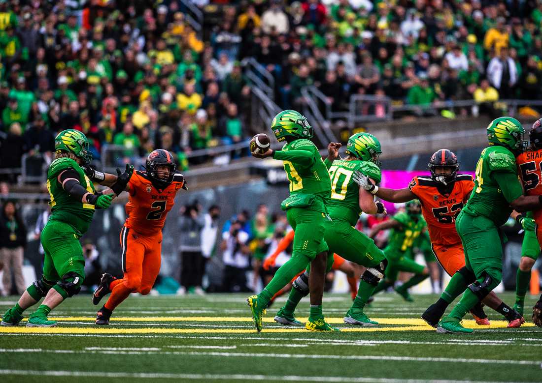 Ducks quarterback Anthony Brown (13) winds back to pass the ball as his teammates attempt to block the Beavers. The University of Oregon Ducks hosted and defeated the Oregon State Beavers 38-29, claiming the Pac-12 North champions title. (Emerald/ Ian Enger)