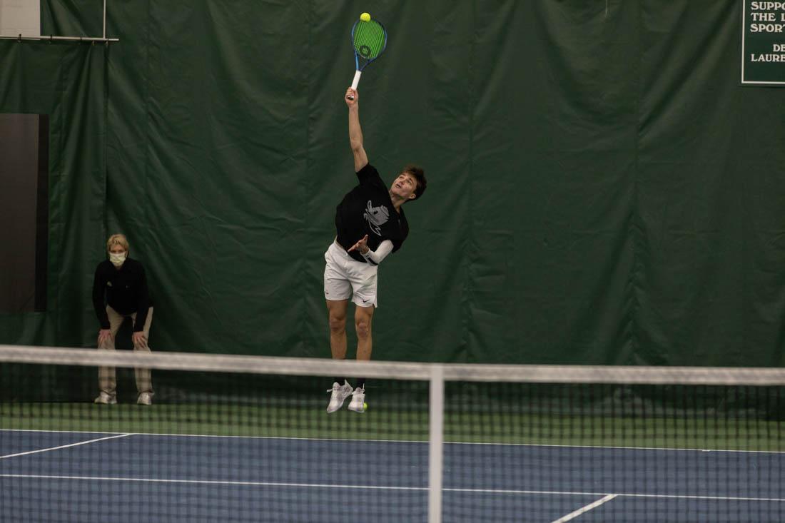 Ducks freshman Quinn Vandecasteele serves towards Boise State defense. Ducks Men's Tennis take on Boise State at the UO Sutdent Tennis Center on Jan. 15, 2022. (Maddie Stellingwerf/Emerald)