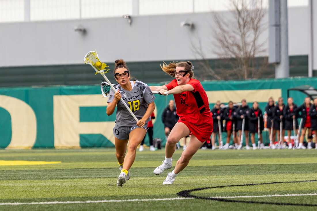 Sophomore Haley Cummins (18) is forced to the side by Cailin Young (18). The Oregon Ducks Women&#8217;s Lacrosse team takes on the SDSU Aztecs, on February 27th, 2022. (Molly McPherson/Emerald)