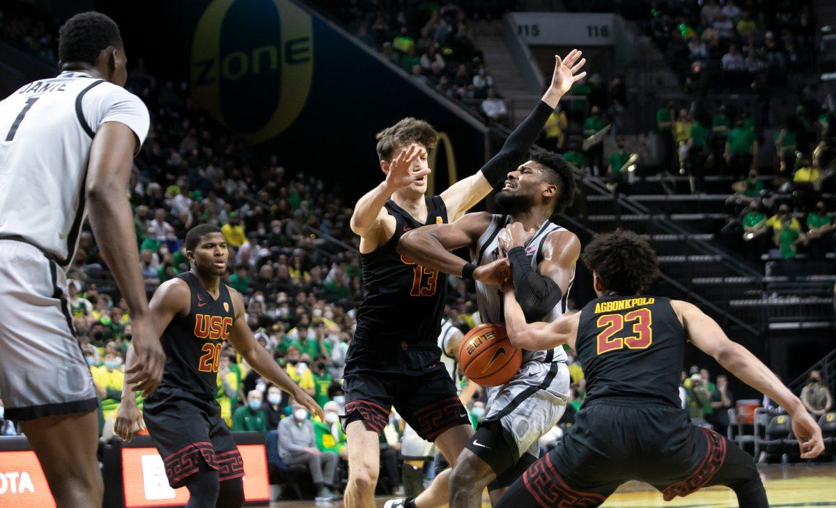 USC defenders strip Quincy Guerrier as he drives to the basket. The Oregon Ducks Men&#8217;s Basketball team faces the USC Trojans, on February 26th, 2022, at Matthew Knight Arena. (Liam Sherry/Emerald)