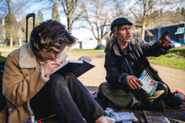 Scarab Powers (left) draws while Charles Petty II (right) discusses the conditions in Washington Jefferson Park. Washington Jefferson Park, which has served as a sanctioned campsite for unhoused people for a year, will be closed by the city soon. (Will Geschke/Emerald)