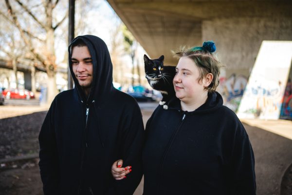 Michael Crockett (left) and Kelsy Somnitz (right) stand in Washington Jefferson Park with their cat Deku. Washington Jefferson Park, which has served as a sanctioned campsite for unhoused people for a year, will be closed by the city of Eugene soon. (Will Geschke/Emerald)