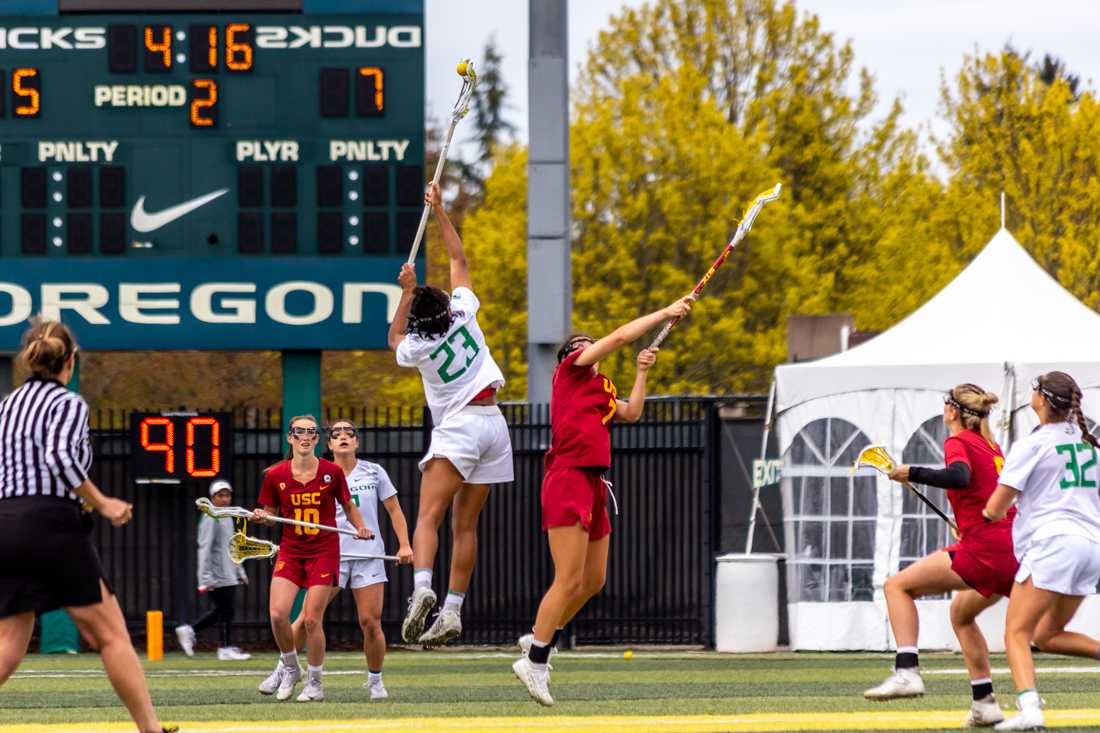 Oregon&#8217;s Nakeeya McCardell (23) leaps above USC&#8217;s Catherine Lord (07) to grab the draw. The Oregon Lacrosse team takes on USC on April 17th, 2022, at Pap&#233; Field. (Molly McPherson/Emerald)