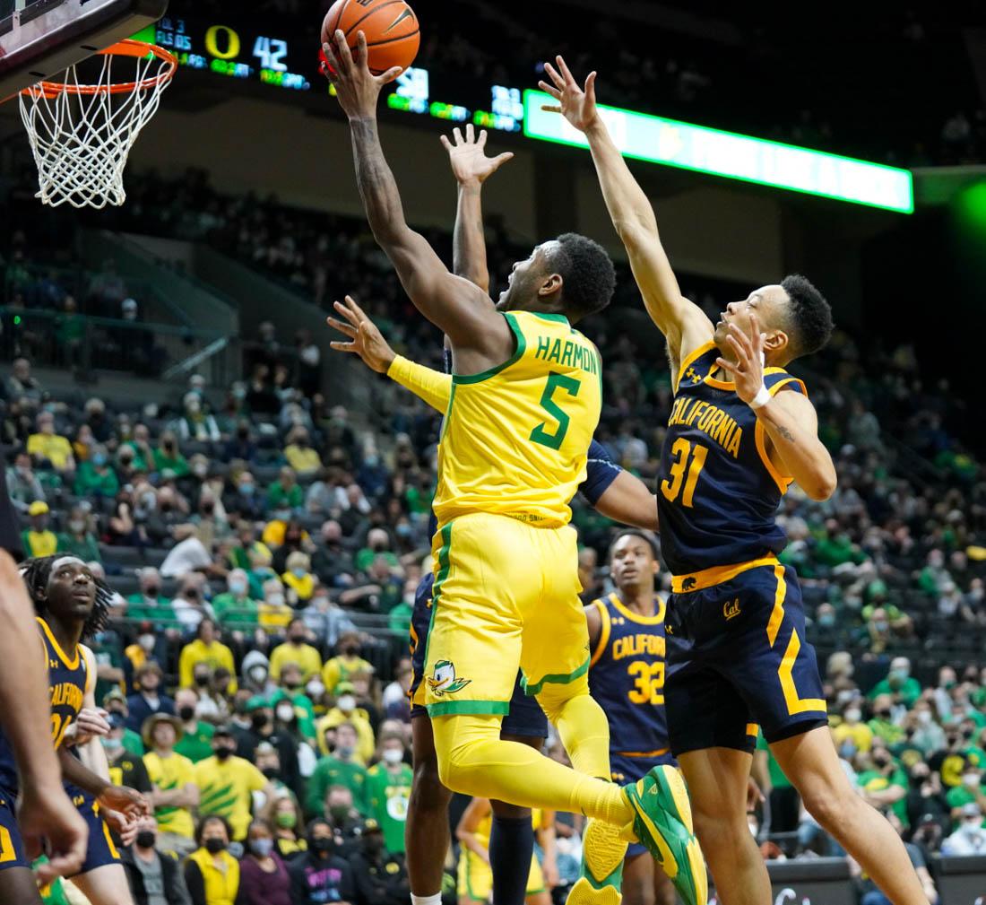 Ducks guard De'Vion Harmon attempts a layup over two defenders. Oregon basketball loses to the California Golden Bears at Matthew Knight Arena in Eugene, Ore. on Feb. 12, 2022. (Jackson Knox/Emerald)