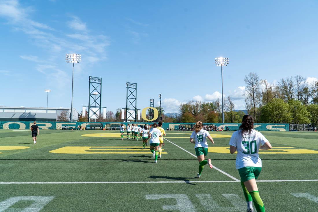 The sun shines down on women's soccer as the Oregon Ducks run onto the field. (Ali Watson/Emerald)