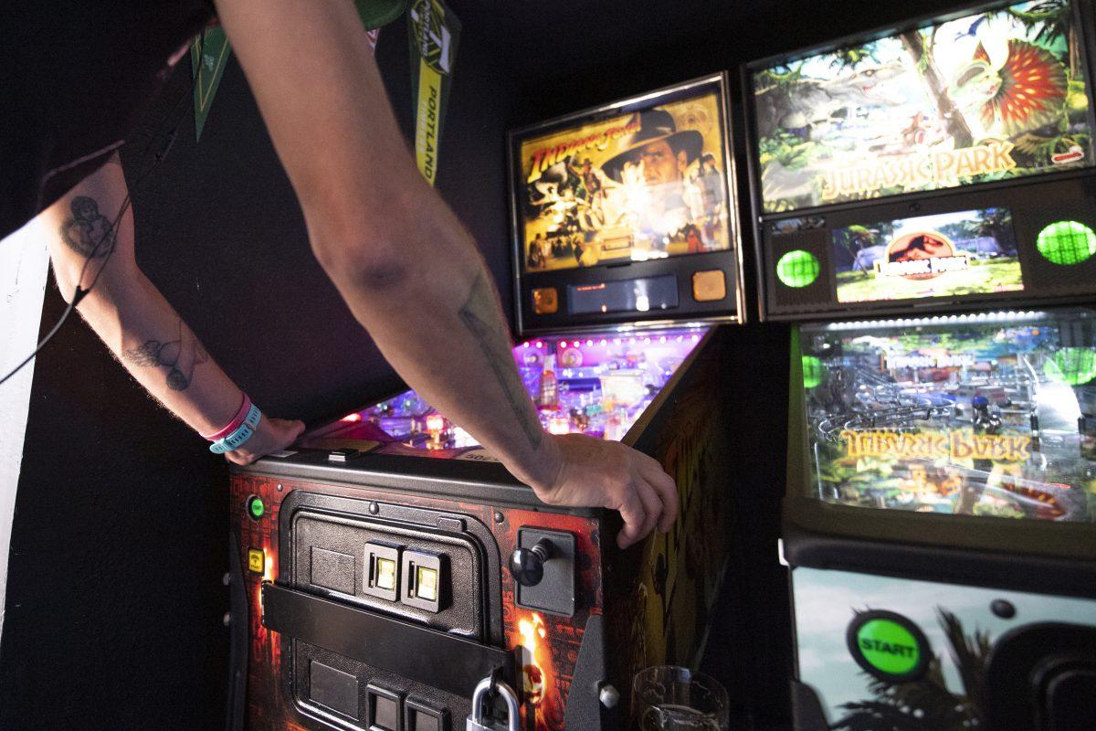 <p>Sam Van Rooy plays pinball at Big City Gamin’ in Eugene, Ore. on September 21, 2021. “I’m here for the Pinball” said Van Rooy. “Great selection of beer and all the games too.” (Isaac Wasserman/ Emerald)</p>