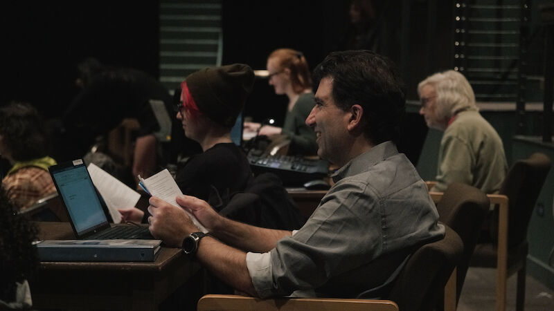 During a stumble-through rehearsal, director Michael Malek Najjar, front, cracks a smile watching the opening scenes of &#8220;She Kills Monsters&#8221; shortly after 8 p.m. on Oct. 24. This is Najjar&#8217;s 11th year at UO, where he has directed a show each year. &#8220;Ultimately, I think it&#8217;s the pinnacle of collaboration in the theatre,&#8221; Najjar said of directing. &#8220;As a director, you are the one that, perhaps, sets the vision of the production, but you have to work with every single department and every single designer and every single actor and every single choreographer.&#8221;