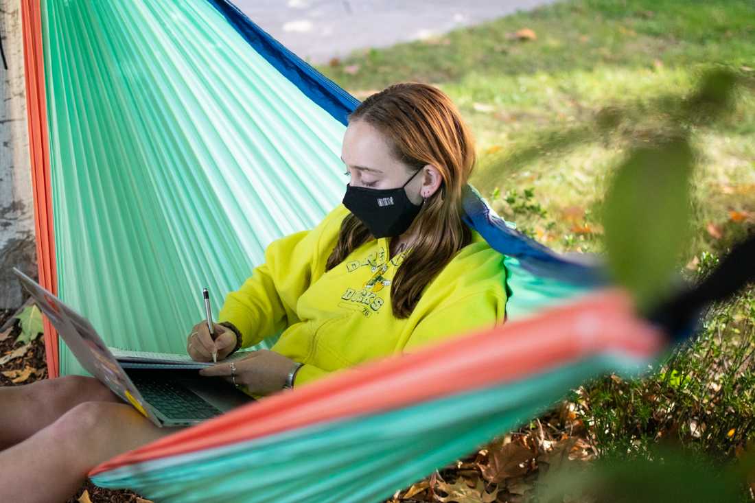 Mady Barth, freshman at UO, does her homework on a hammock that she up set up between two trees on campus.