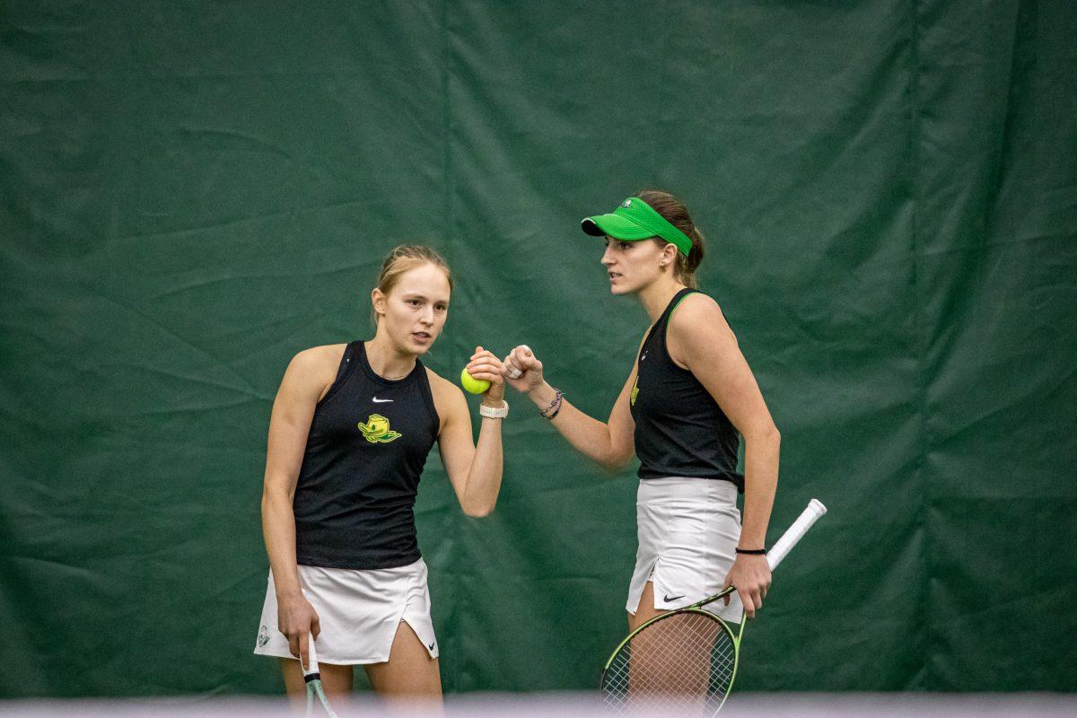 Sophie Luescher and Ares Garcia bump fists in between sets.&#160;The Oregon Women's Tennis team hosts Portland State at the Student Tennis Center in Eugene, Ore., on January 20th. (Jonathan Suni, Emerald)